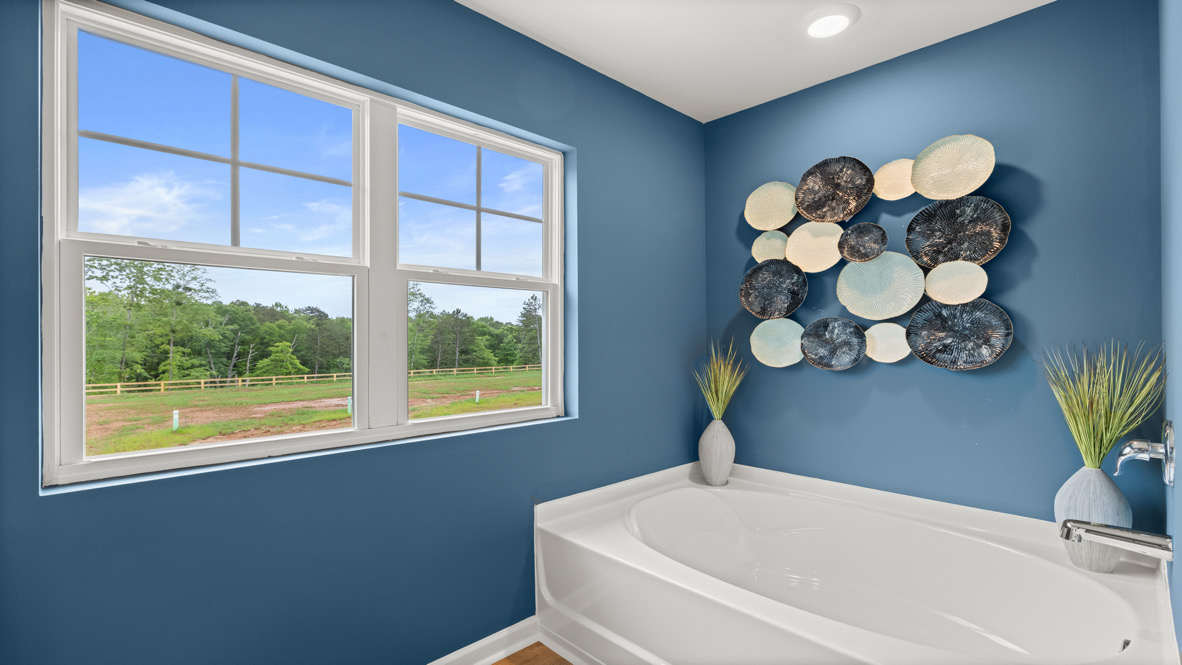 Interior primary bathroom with bath tub and window