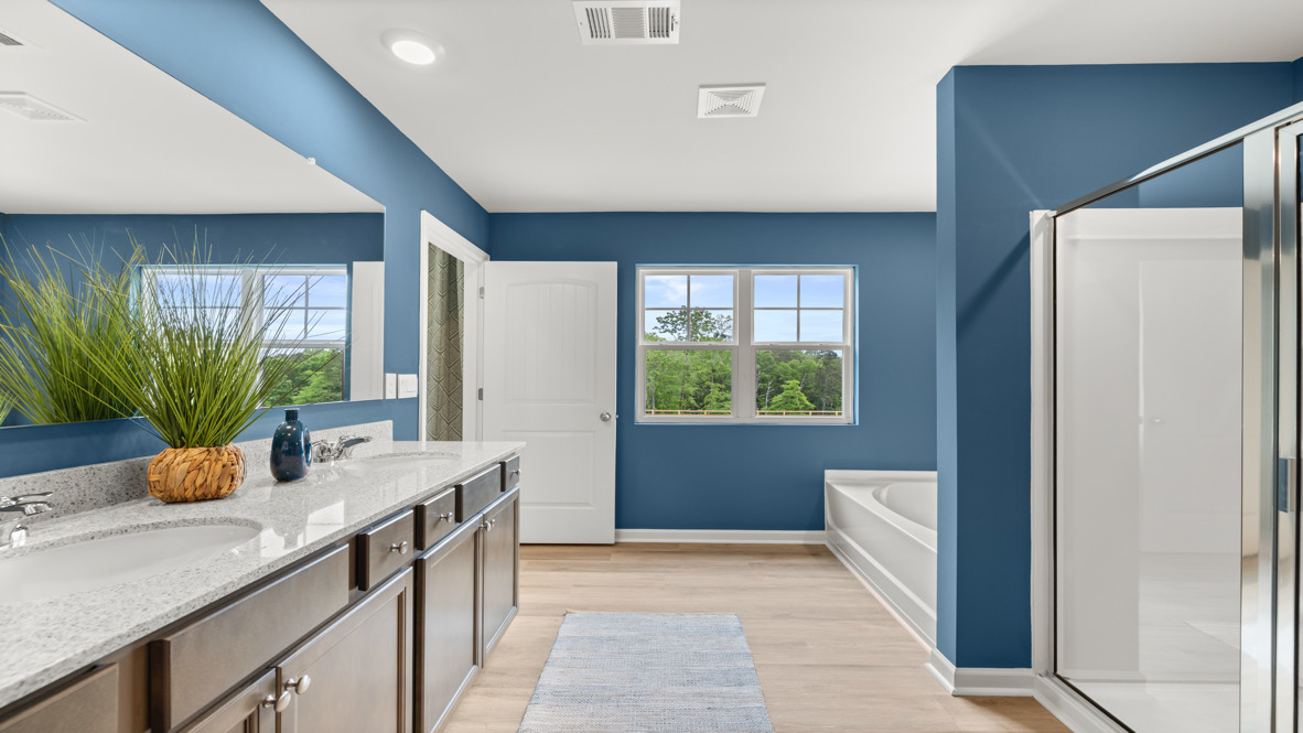Interior primary bathroom with double sink, bath tub and shower