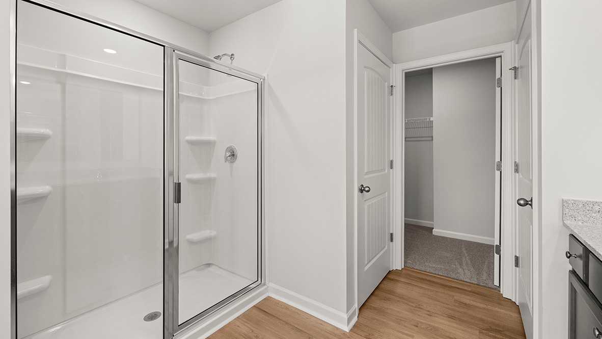 Interior primary bathroom with shower and walk-in closet