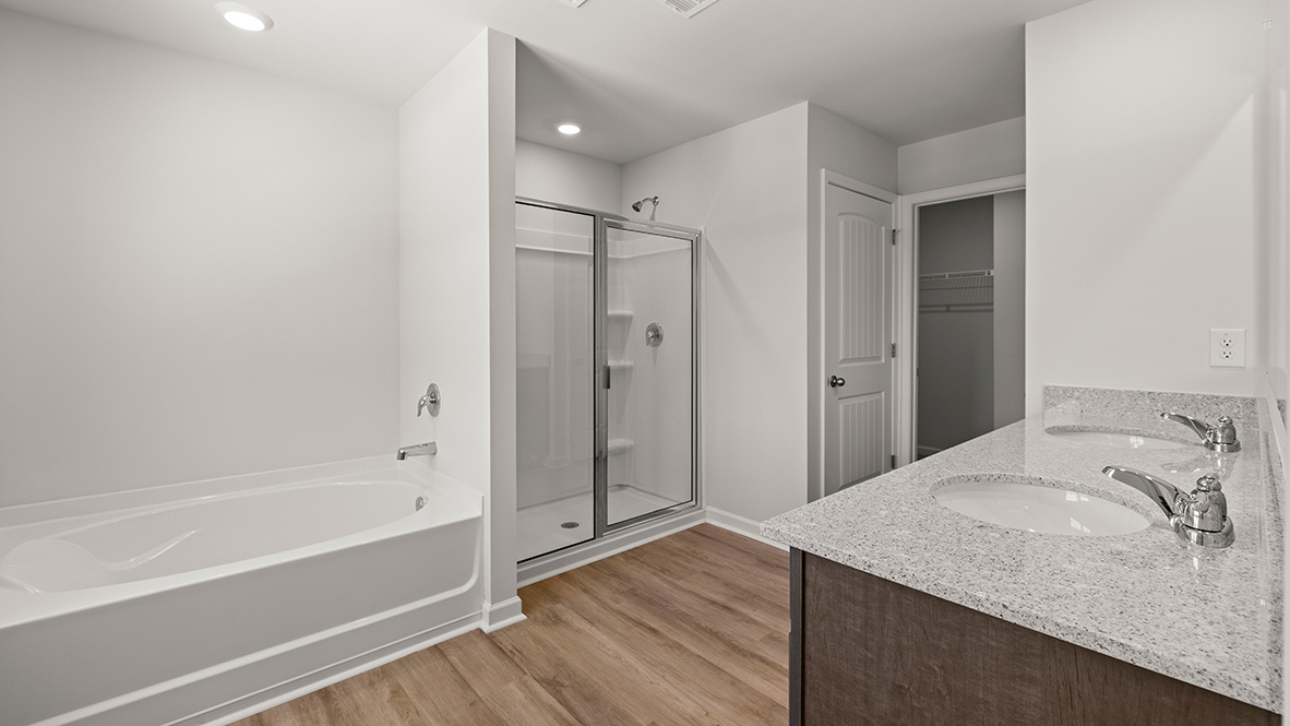 Interior primary bathroom with double sink, bath tub and shower