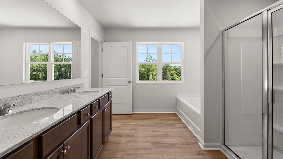 Interior primary bathroom with double sink, bath tub and shower