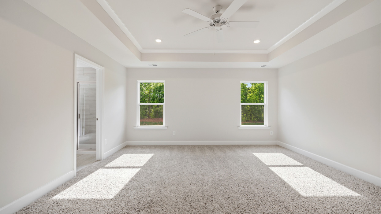 primary bedroom with natural light and ceiling fan