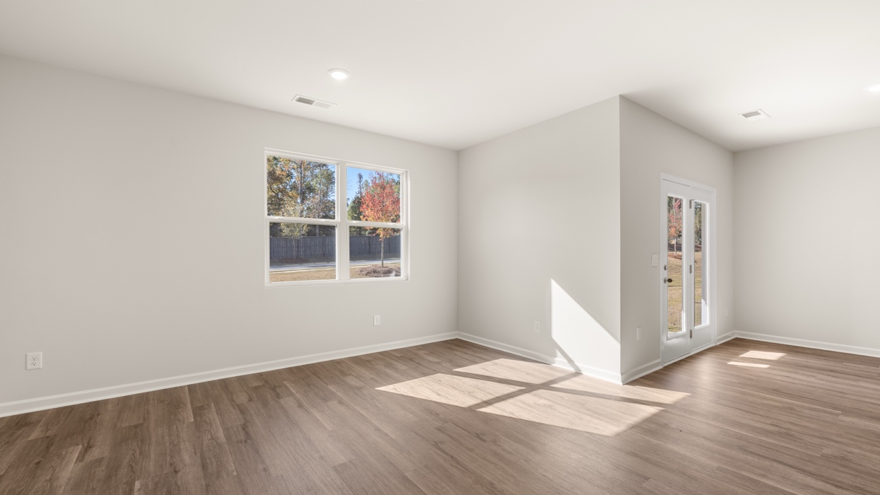 angled living room with natural light and dining room with access to patio