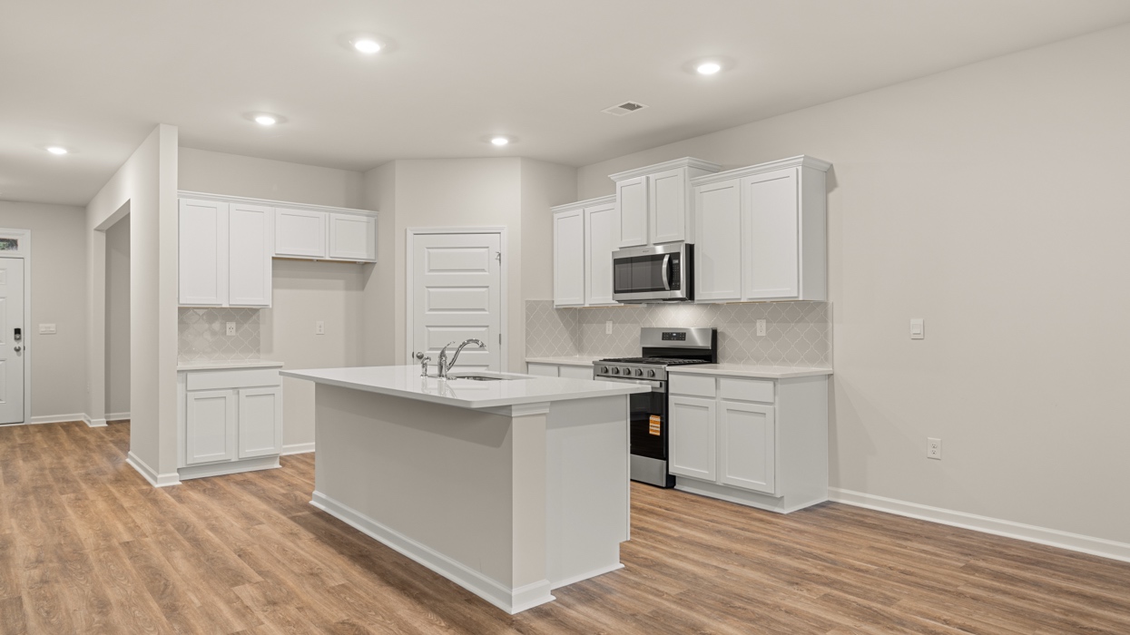 angled kitchen with spacious white cabinets and large center island