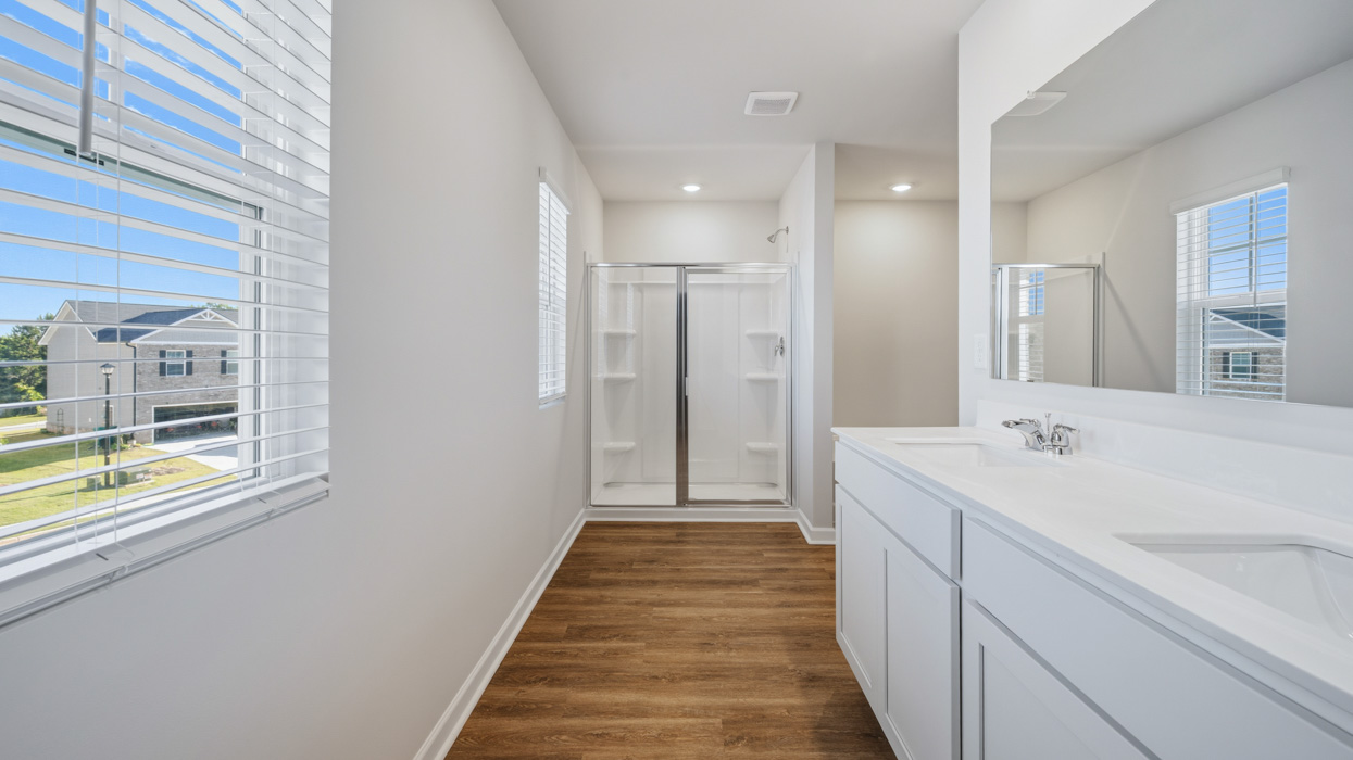 primary bathroom with dual sinks and natural light