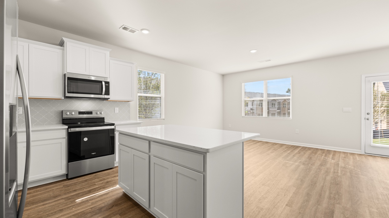 angled kitchen with spacious white cabinetry and large center island