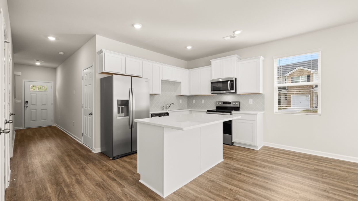 angled kitchen with spacious white cabinetry and large center island