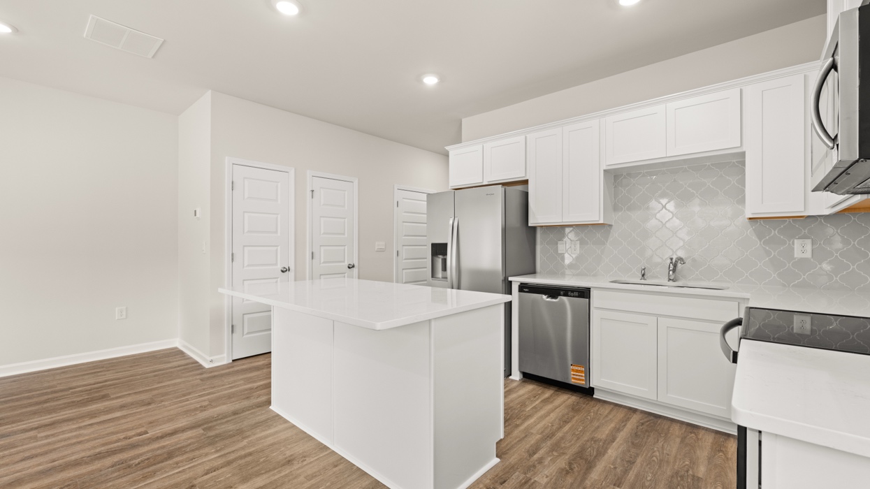 angled kitchen with spacious white cabinetry and large center island