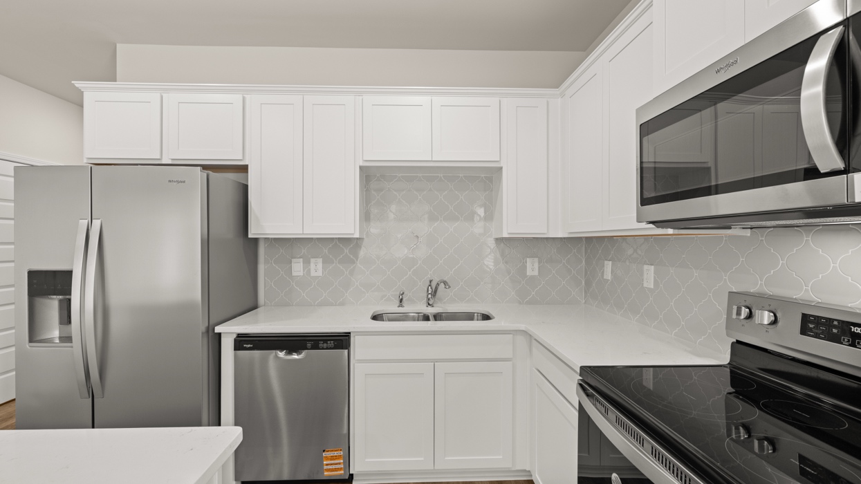 angled kitchen with spacious white cabinetry and large center island