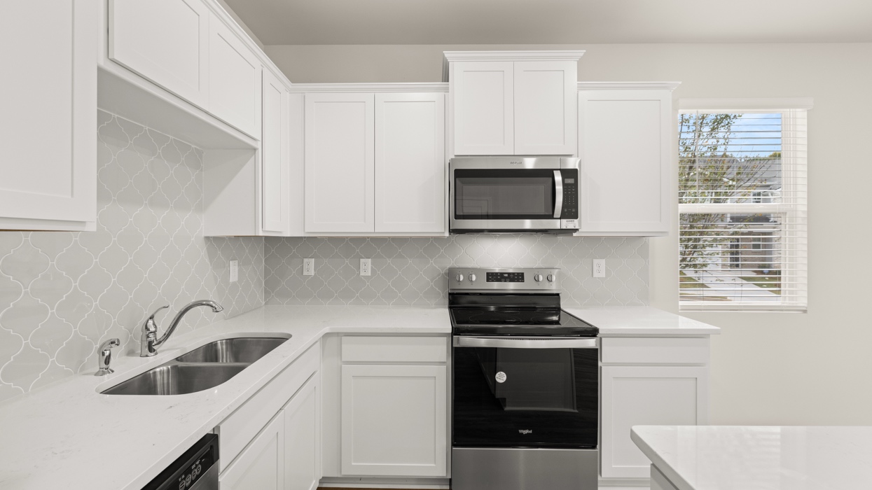 angled kitchen with spacious white cabinetry and large center island