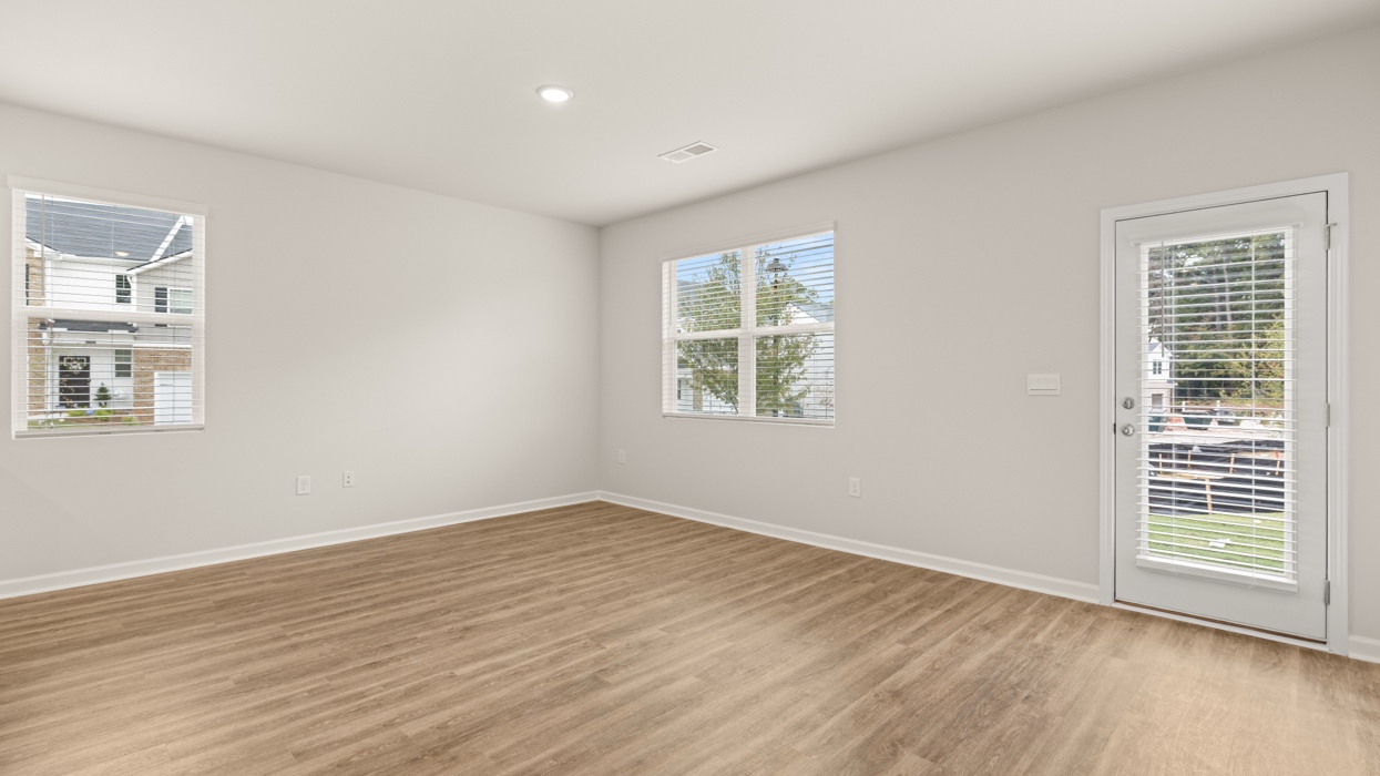 angled breakfast room and living room with natural light and rear patio access
