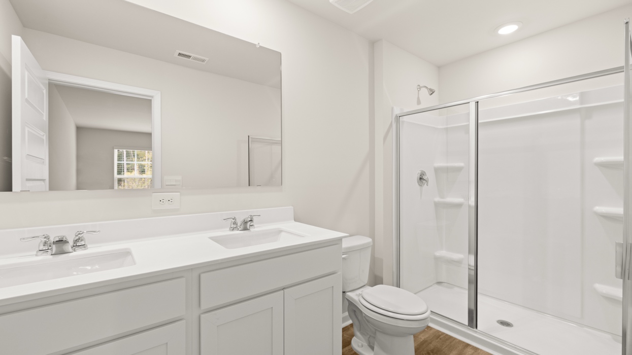 primary bathroom with dual sinks and walk-in shower