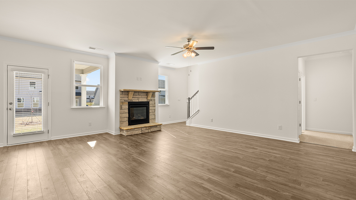 angled living room with natural light and ceiling fan