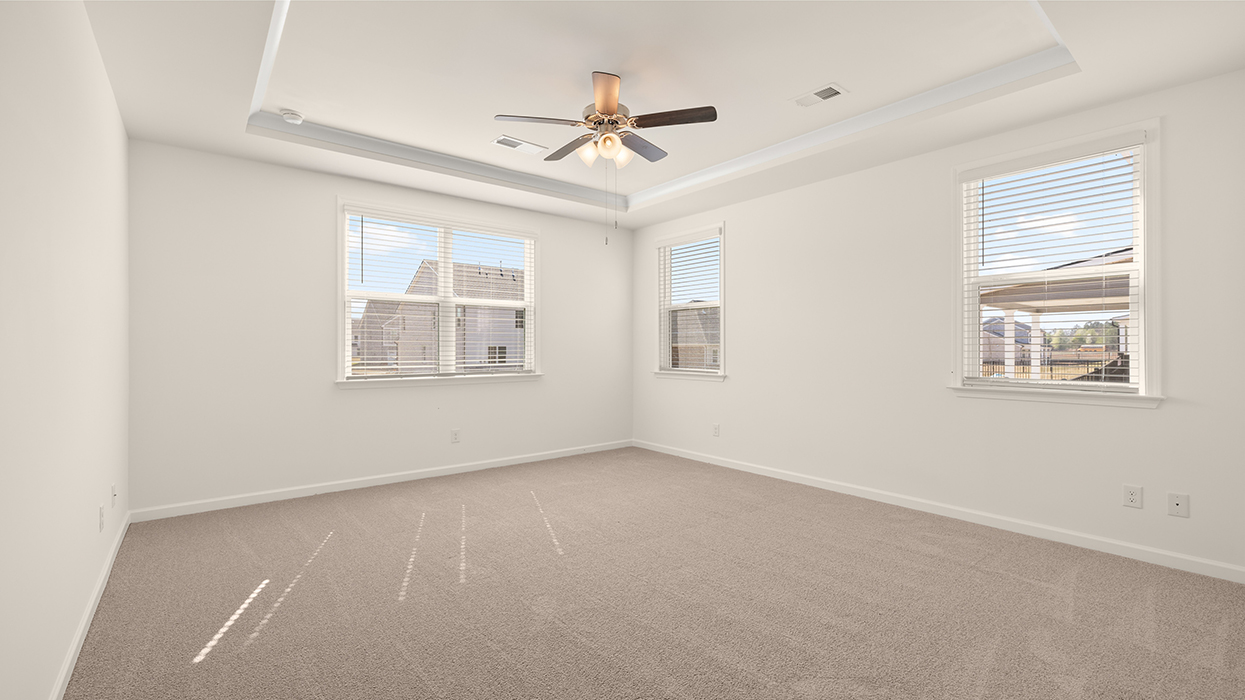 primary bedroom with abundance of natural light and ceiling fan
