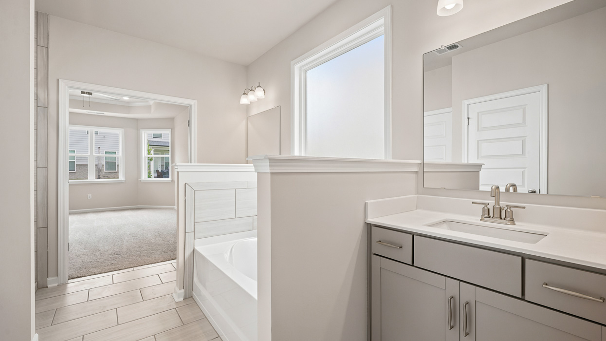 primary bathroom with soaking tub and split owners sinks