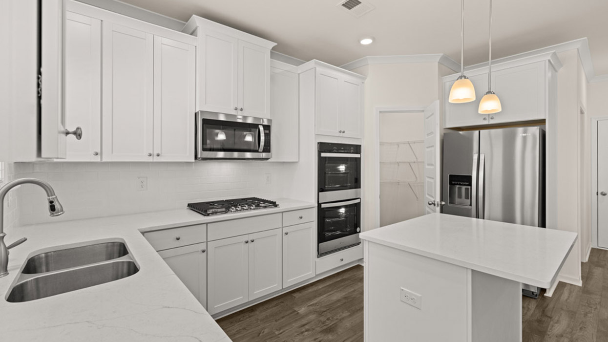 angled kitchen with spacious white cabinets and center island