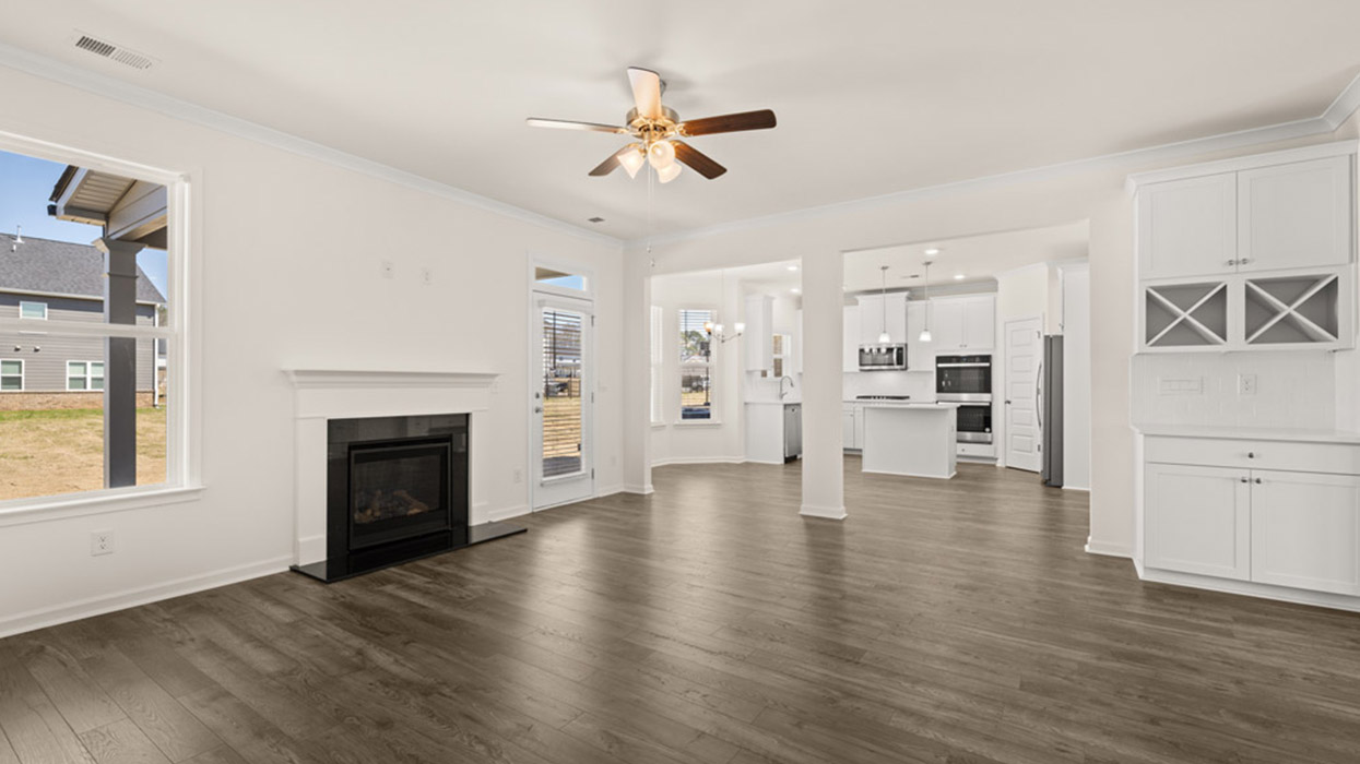 angled living room with ceiling fan and natural light with patio access