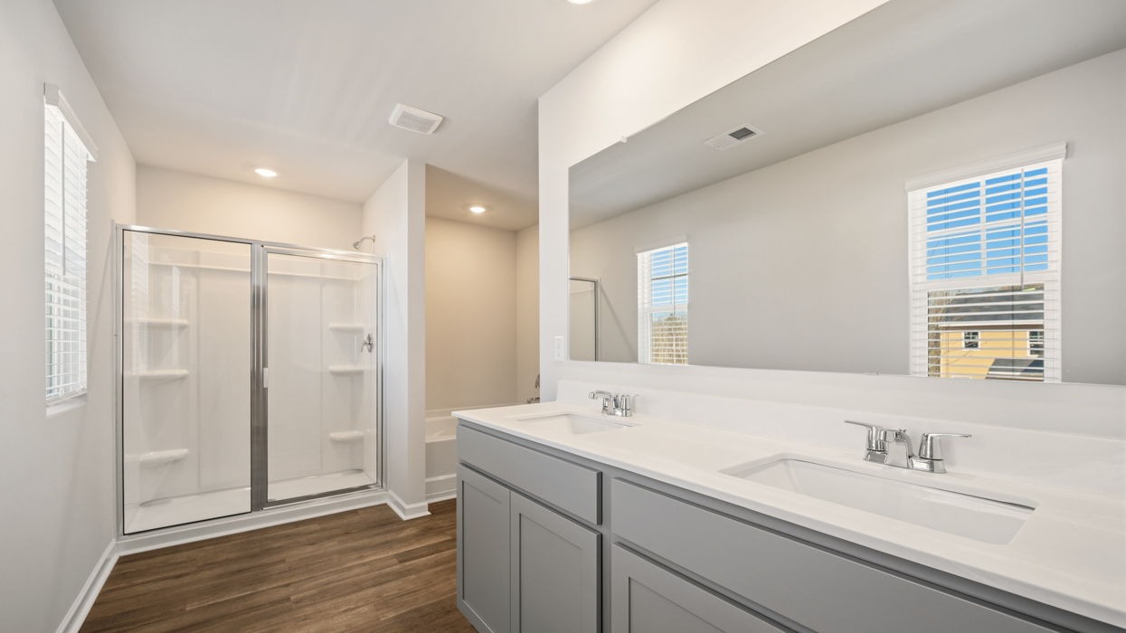 angled primary bathroom with angled sinks