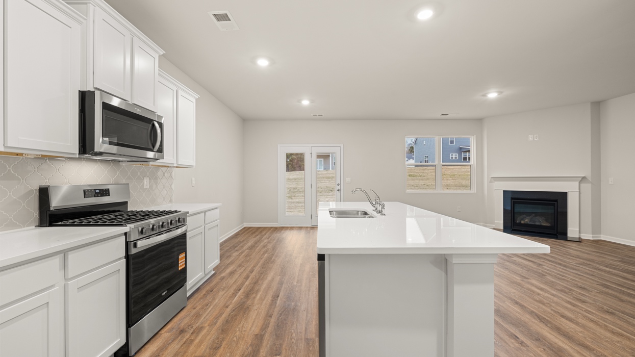 angled kitchen with spacious white cabinetry and large center island