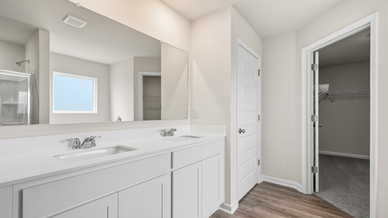 angled primary bathroom with dual sinks