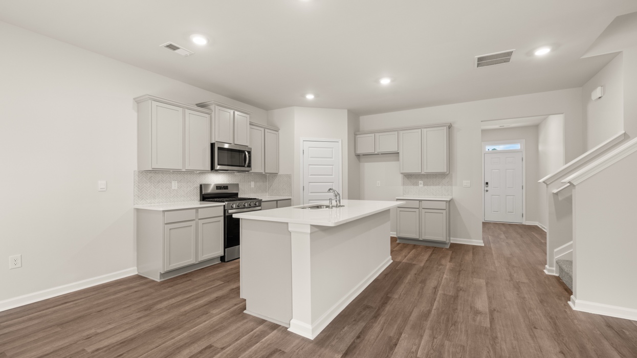 angled kitchen with large center island with spacious gray cabinetry