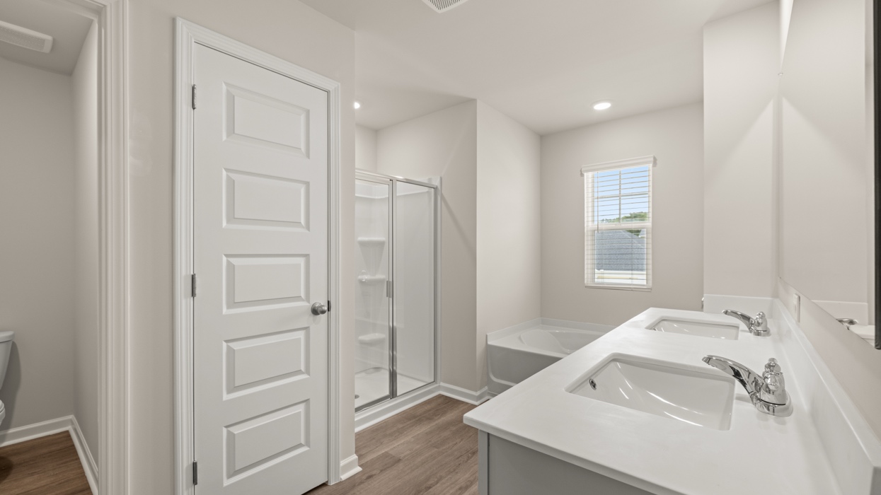 primary bathroom with dual sinks and natural light