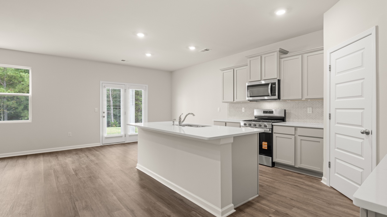 angled kitchen with large center island with spacious gray cabinetry