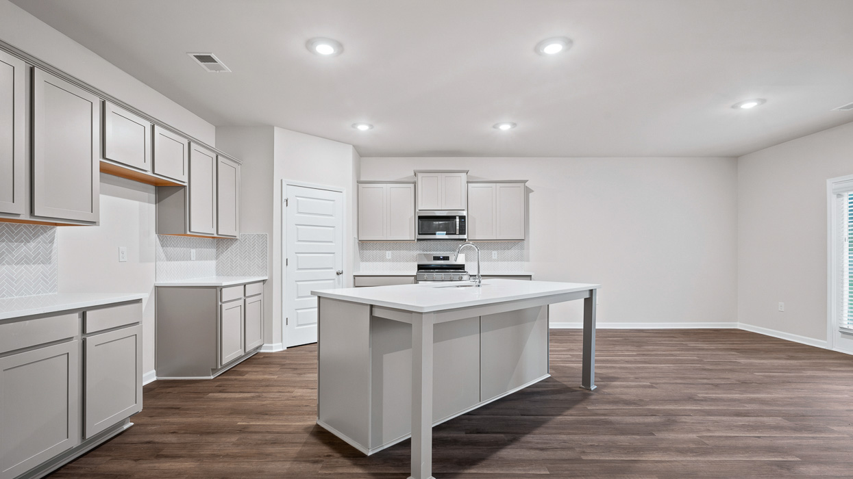 angled kitchen with spacious gray cabinetry and large center island