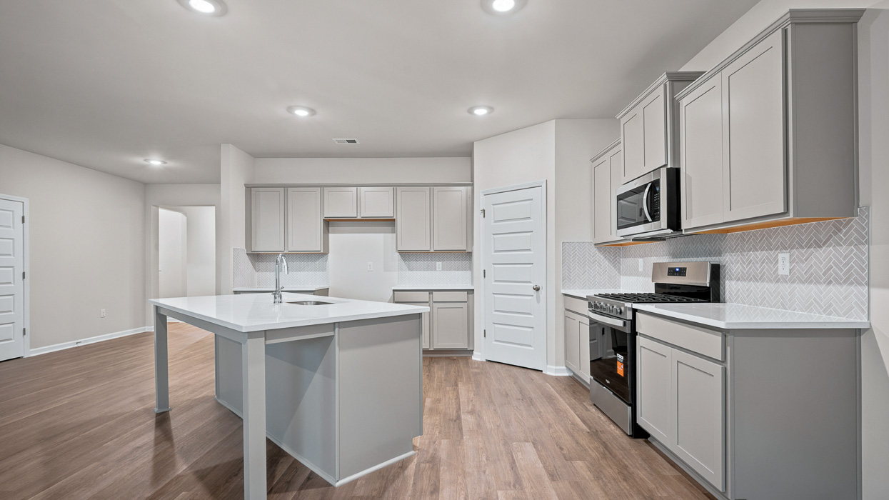 angled kitchen with spacious gray cabinetry and large center island