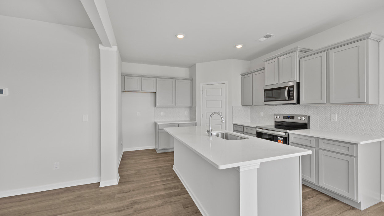 angled kitchen with spacious gray cabinetry and large center island