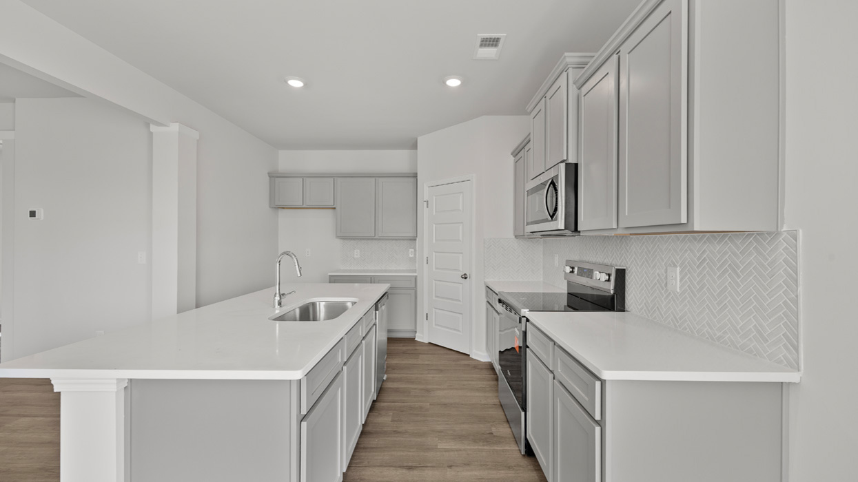 angled kitchen with spacious gray cabinetry and large center island