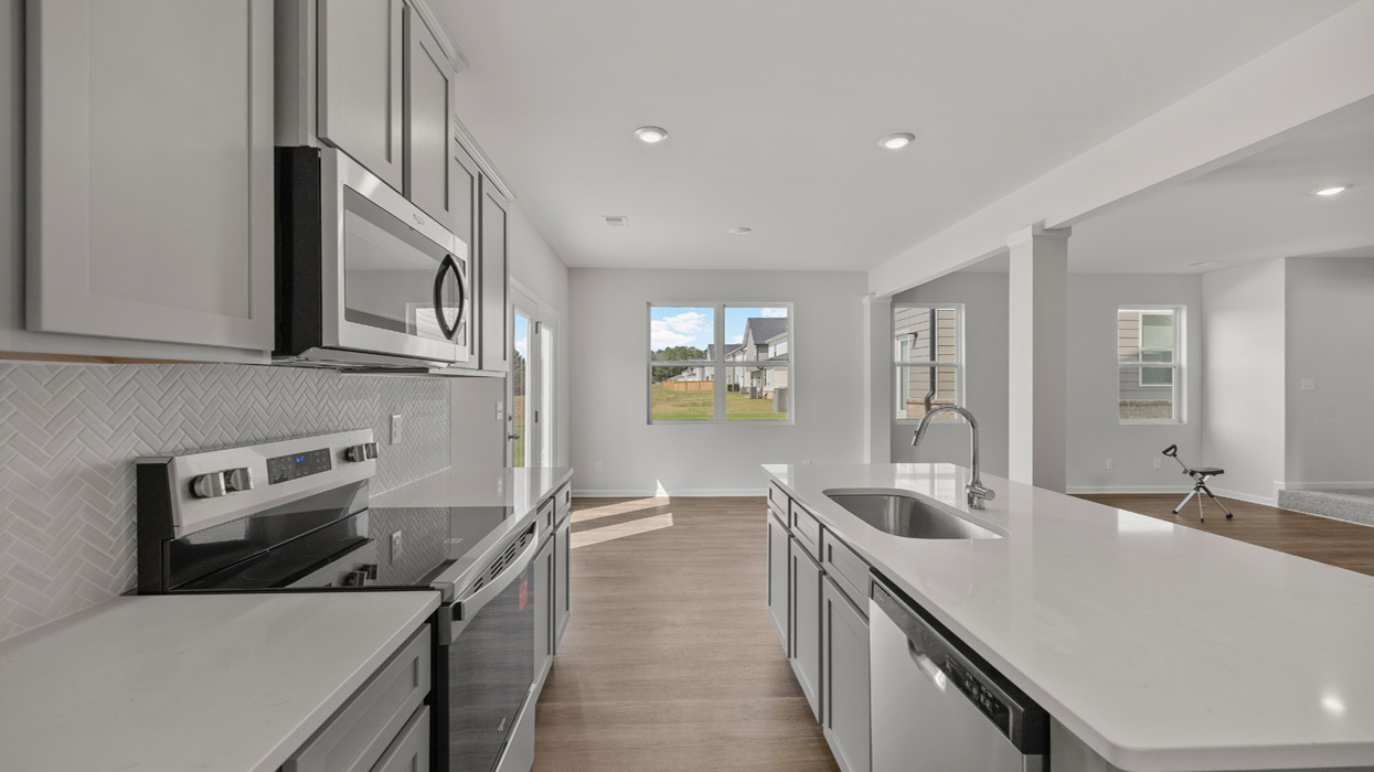 angled kitchen with spacious gray cabinetry and large center island
