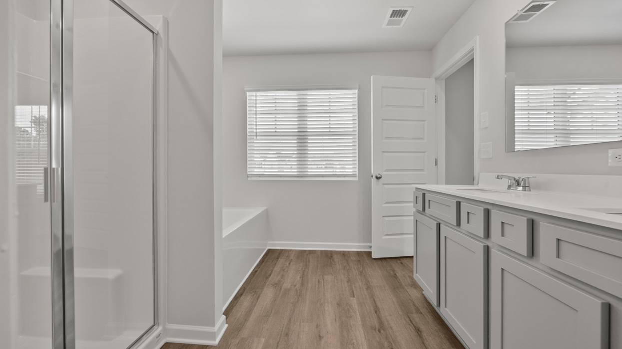 primary bathroom with dual sinks and natural light