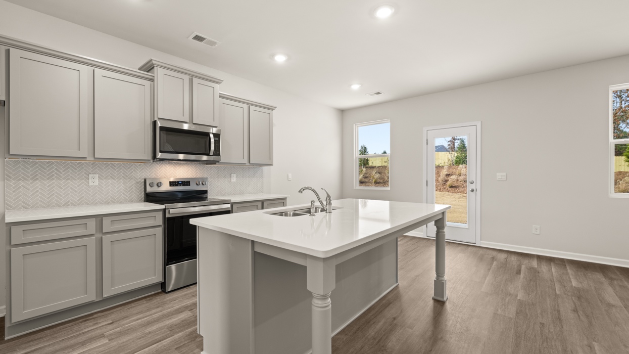 angled kitchen with large center island and spacious gray cabinetry