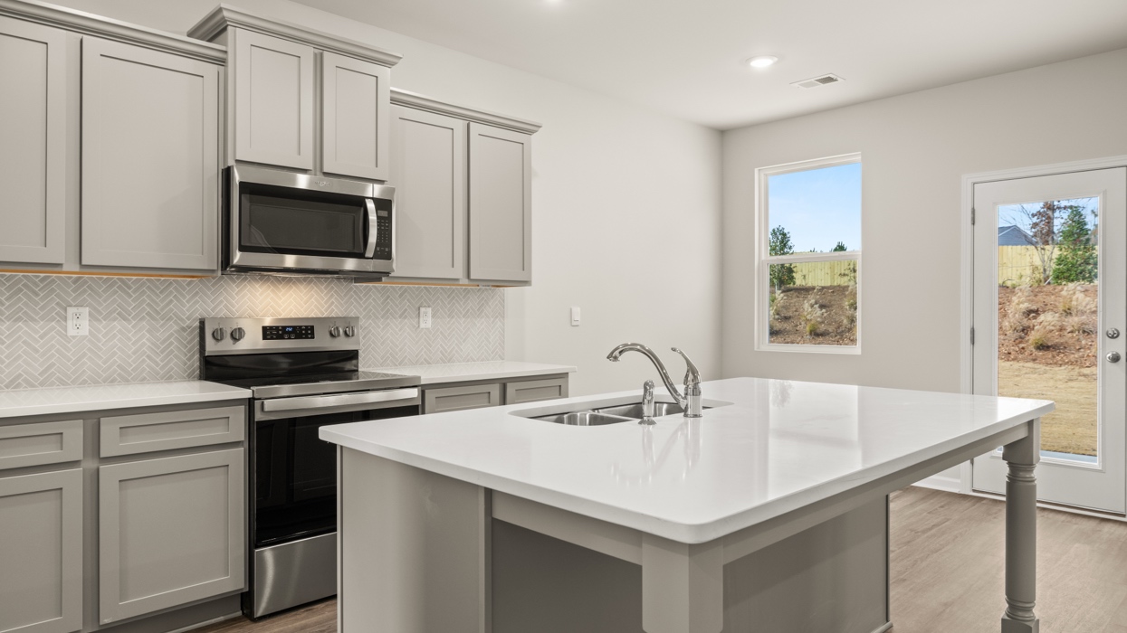 angled kitchen with large center island and spacious gray cabinetry