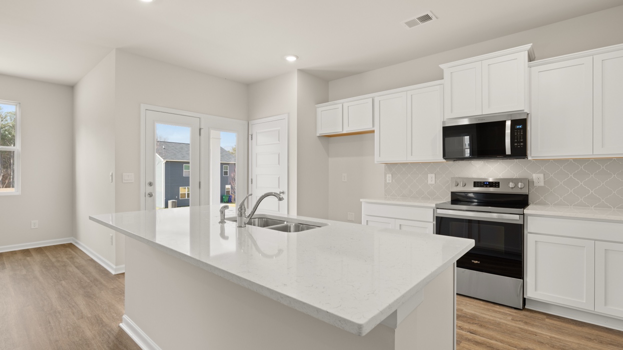angled kitchen with spacious white cabinetry and large center island