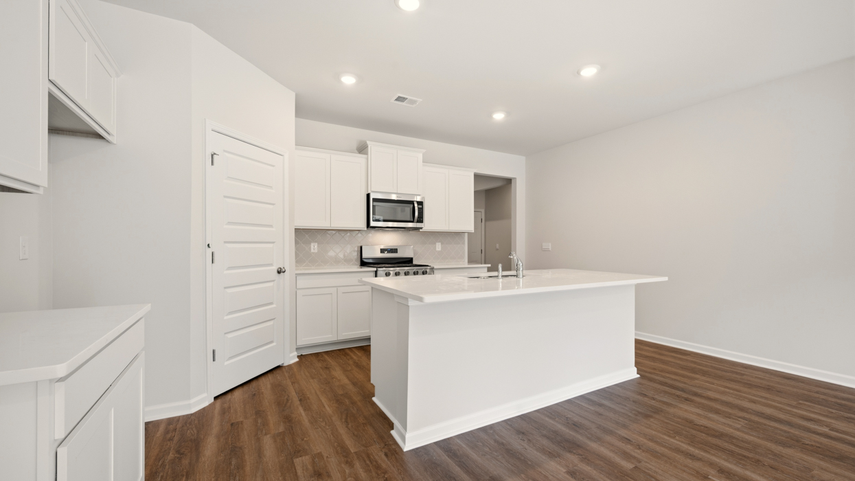 angled kitchen with spacious white cabinetry and large center island
