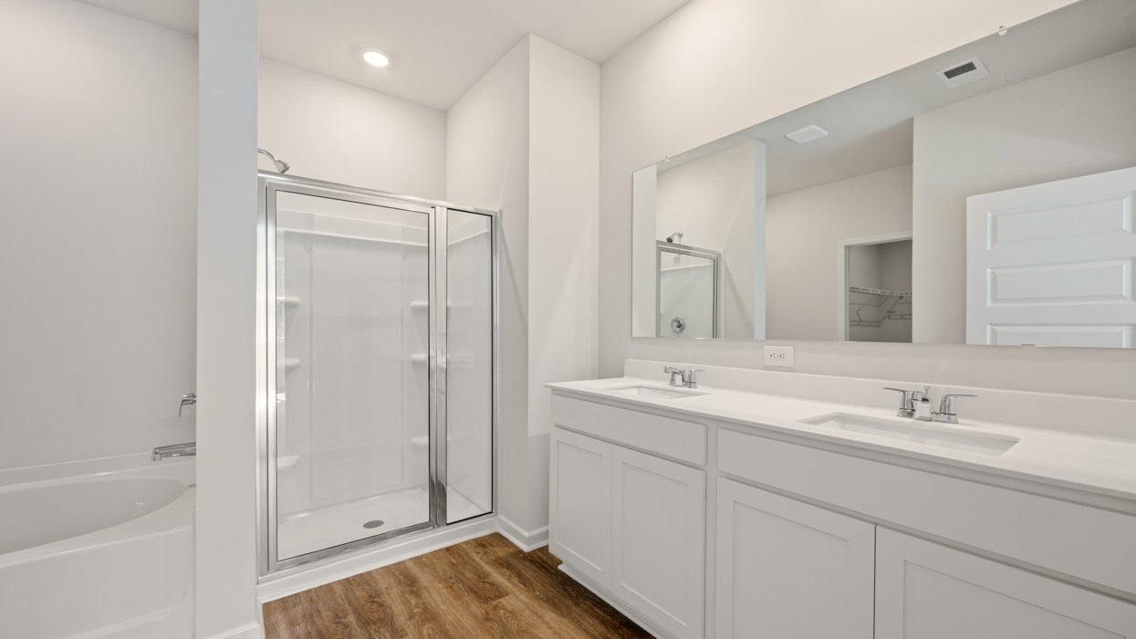 primary bathroom with dual sinks and walk-in shower
