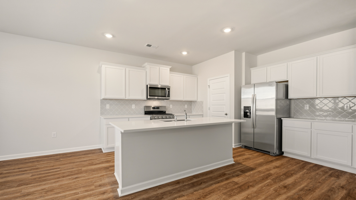 angled kitchen with spacious wite cabinetry and large center island