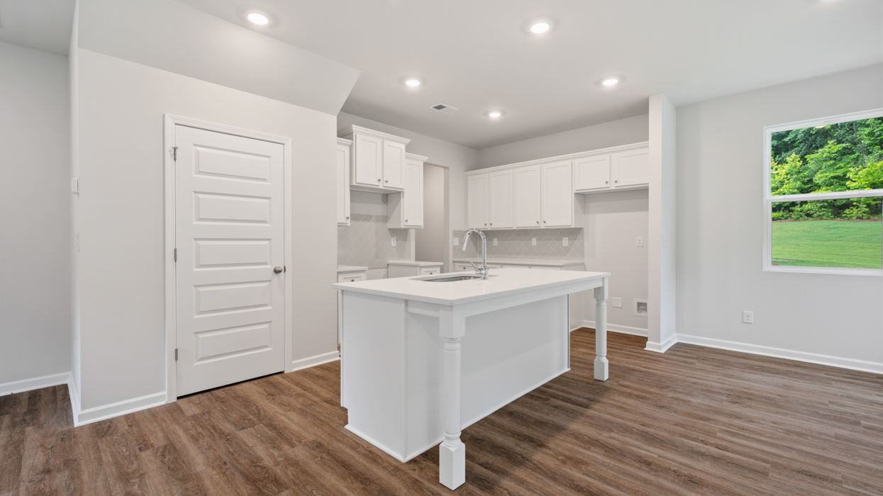 angled kitchen with spacious white cabinetry and large center island