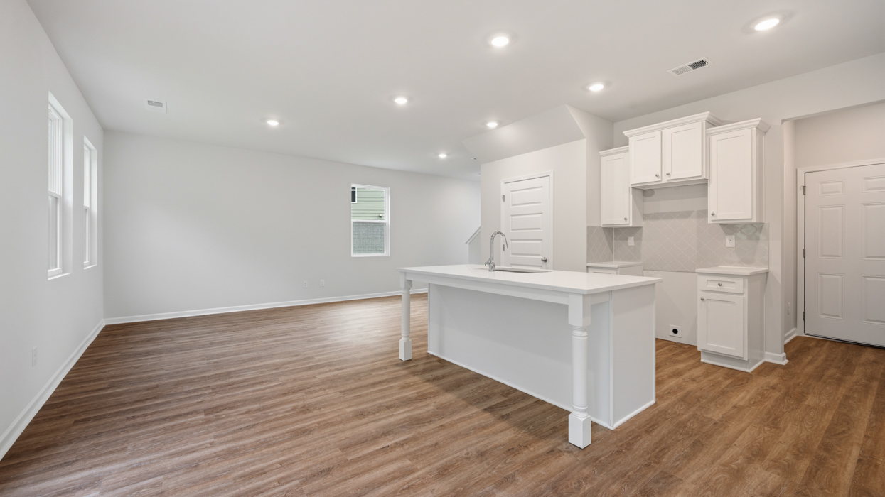 angled kitchen with spacious white cabinetry and large center island