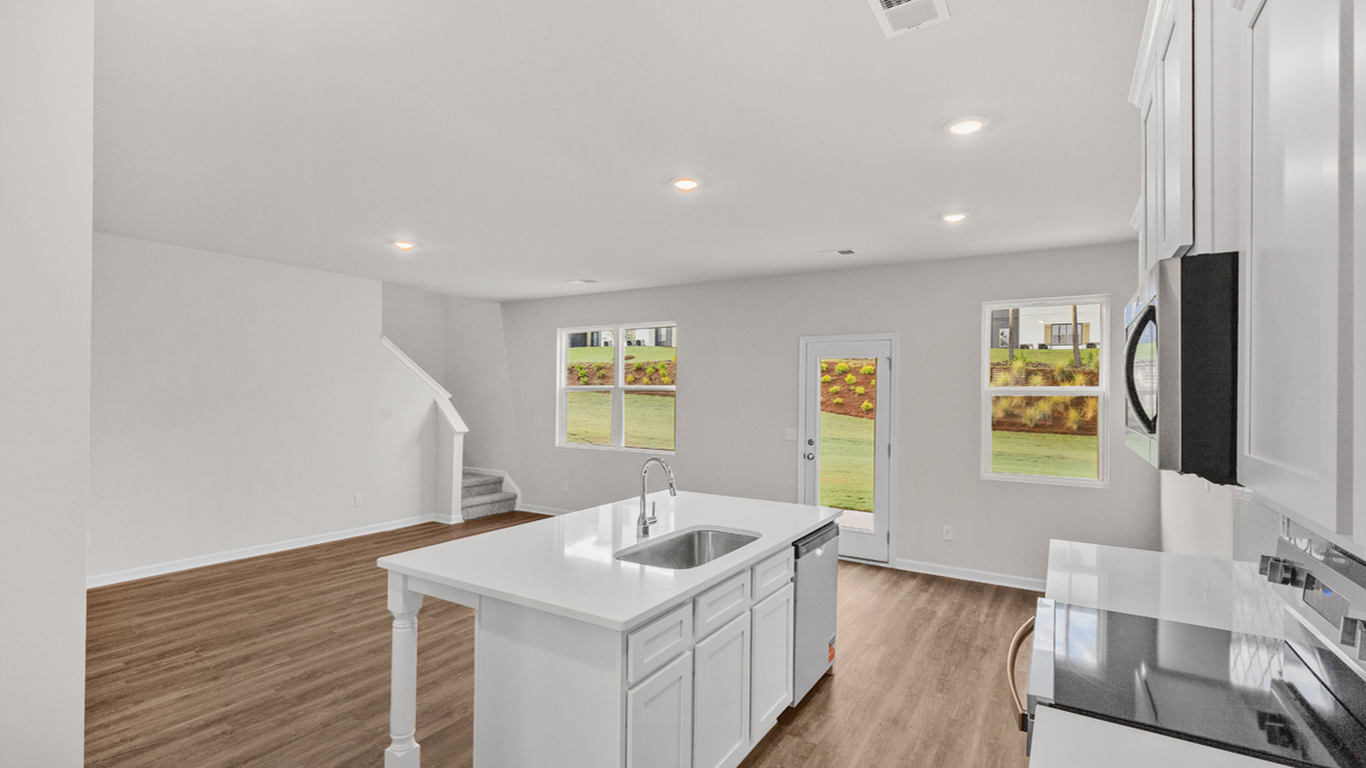 kitchen overview of island with sink into the breakfast nook and family room