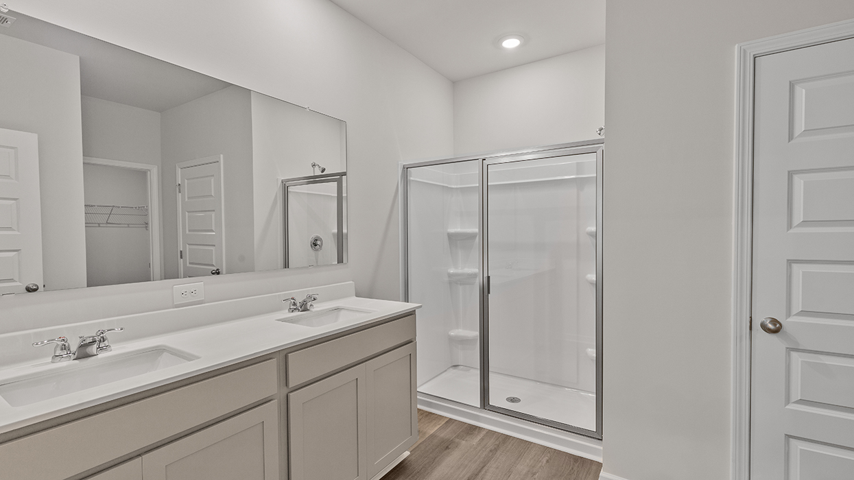 primary bathroom with dual sinks  and walk-in shower