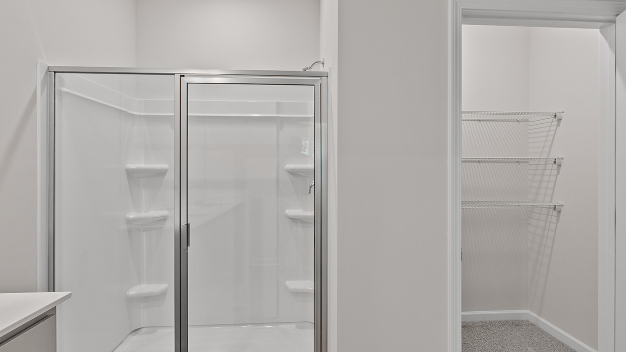 primary bathroom with walk-in shower and closet