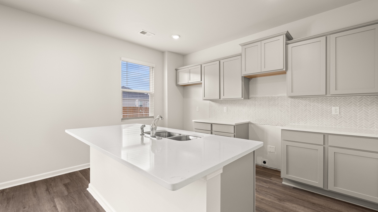 angled kitchen with spacious grey cabinetry and large center island
