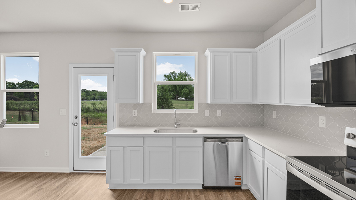 angled kitchen with spacious gray cabinetry with natural light