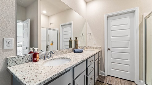 Dual sink vanity with granite countertops.