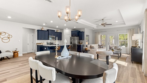Open floorplan in Mobile with navy cabinets, luxury vinyl plank and recessed lighting.