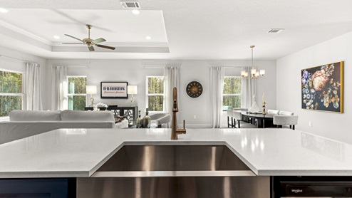 Kitchen island with navy blue cabinets and stainless steel farmhouse sink.