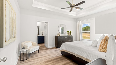 Spacious bedroom with white and blue neutral decor.